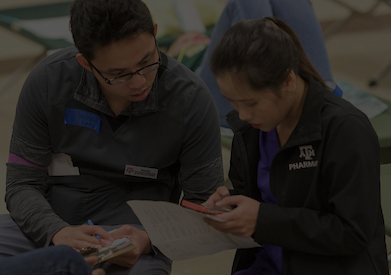 Pharmacy student speaking to nursing student on Disaster Day